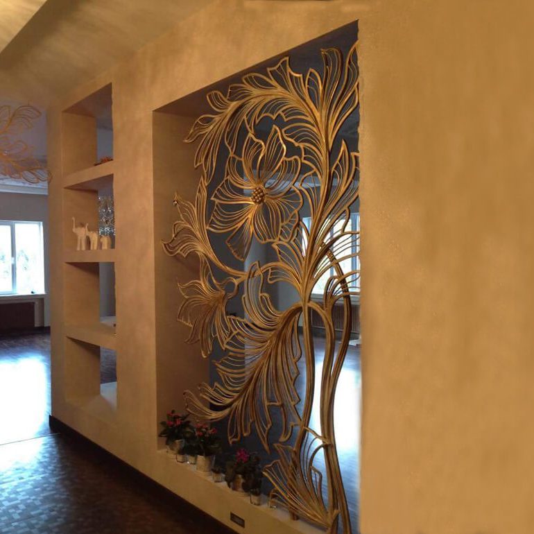 Custom architectural metal wall sculpture with intricate floral design in a luxury interior.